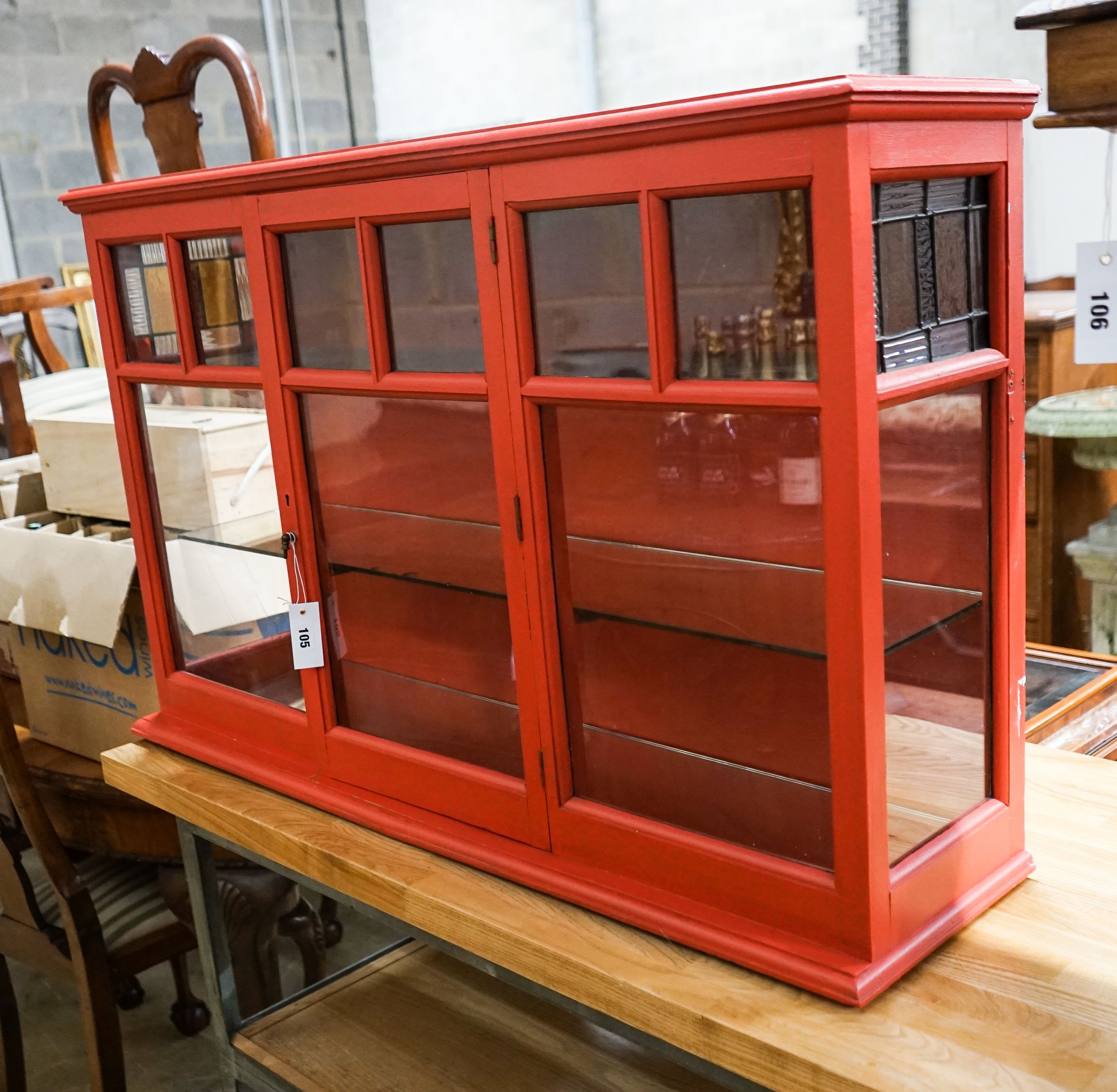 A painted glazed two door wall cabinet with mirrored interior, width 109cm, depth 26cm, height 68cm